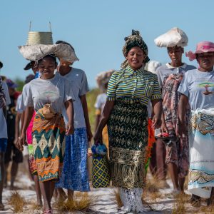 Eden People+Planet community gathering with diverse women in traditional attire planting trees outdoors.